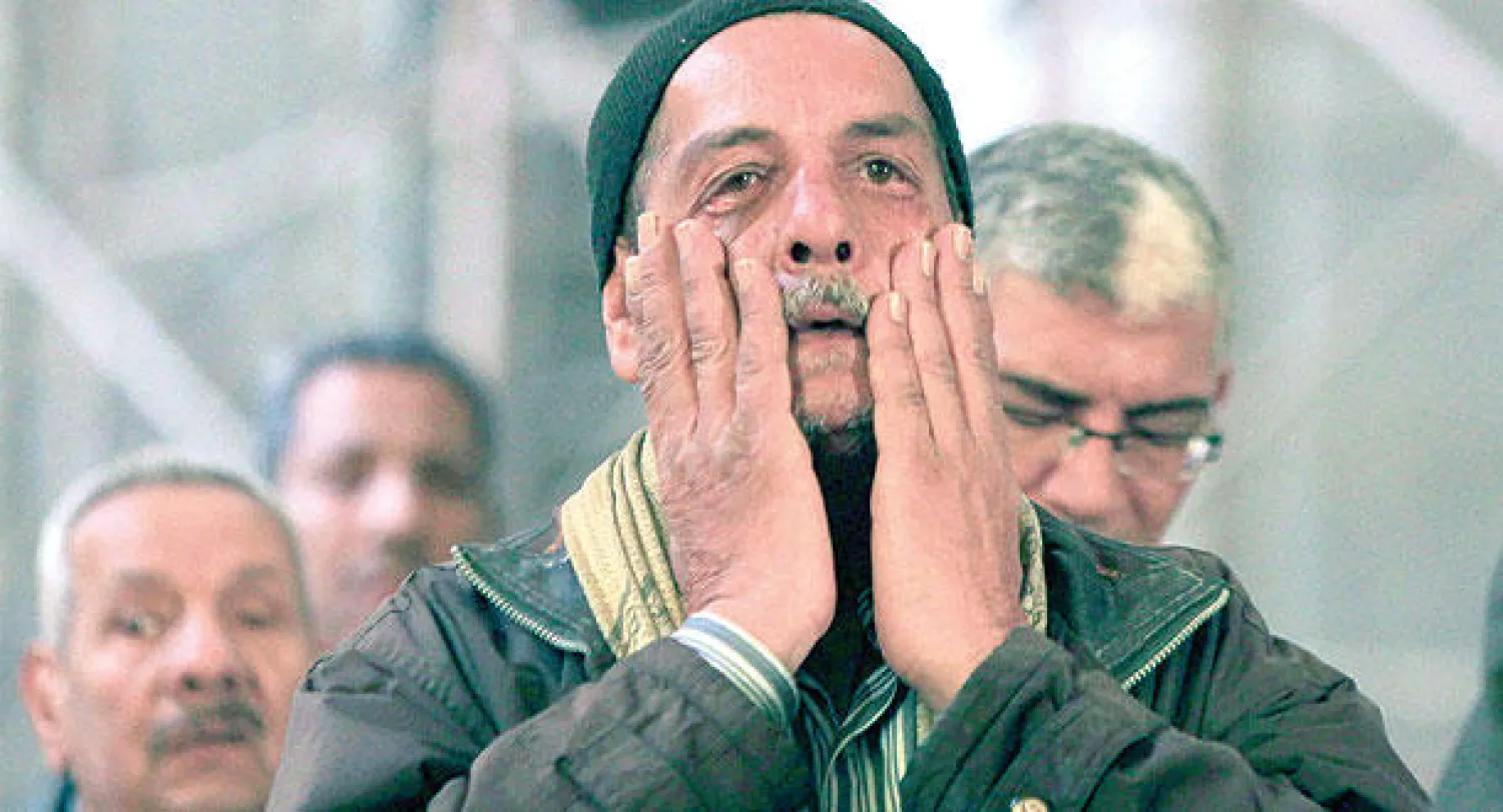 مواطن مصري يشارك في قداس تأبين المصريين المسيحيين الذين ذبحهم «داعش» في ليبيا.. وذلك داخل كاتدرائية «مار مرقس» بالقاهرة أمس (رويترز)