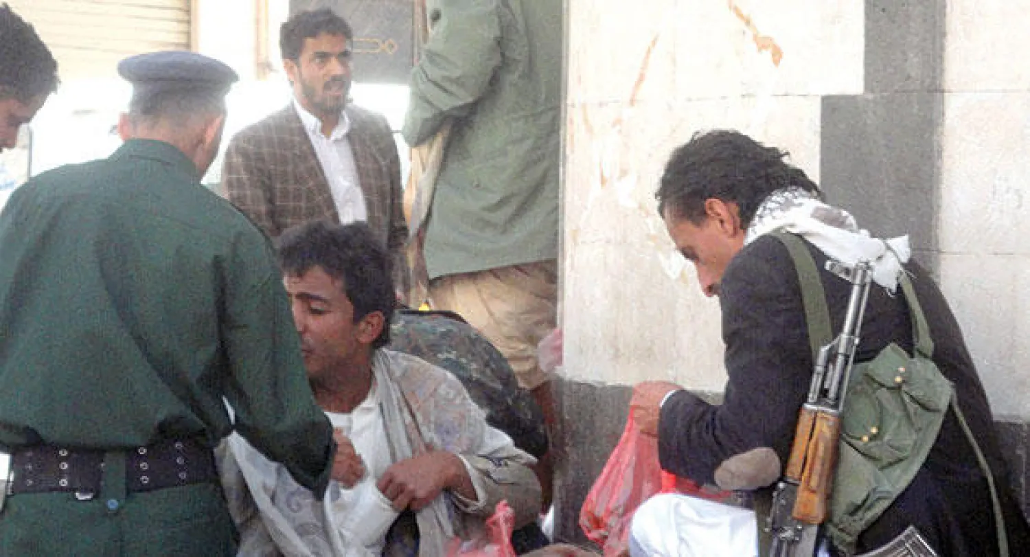 مسلح حوثي أثناء شرائه لنبتة القات أمس في صنعاء («الشرق الأوسط»)