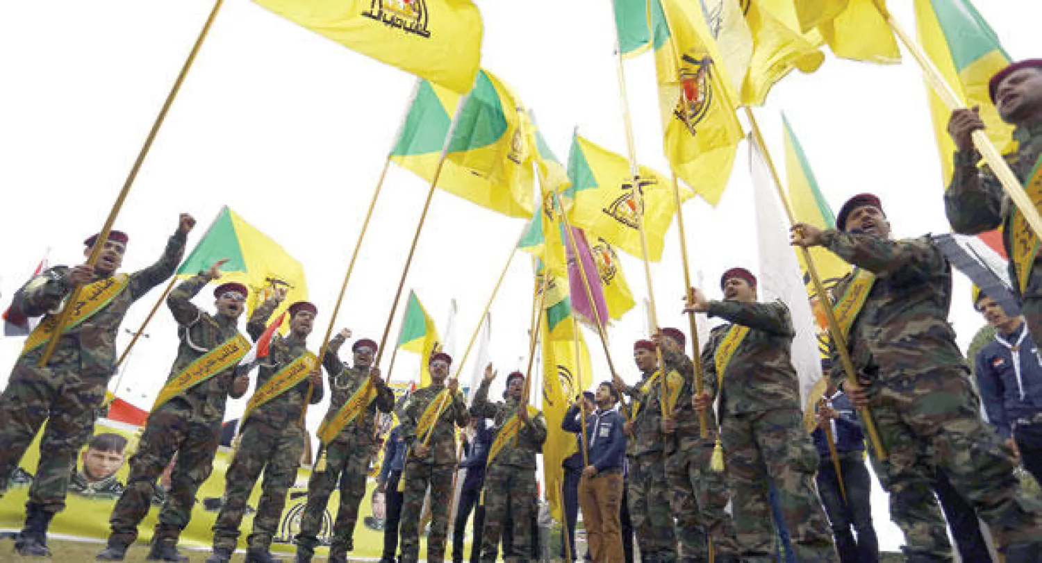 عرض لأفراد من ميليشيا حزب الله الشيعية المشاركة في الحشد الشعبي في مدينة النجف أمس (أ.ف.ب)