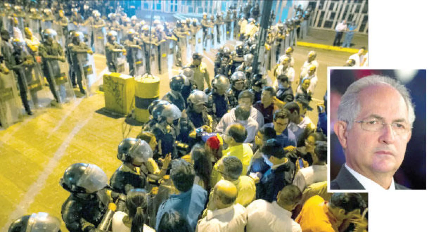 الشرطة تحرس مقر الاستخبارات في العاصمة الفنزويلية بعد اعتقال رئيس بلدية كاراكاس المعارض أنطونيو ليديزما (صاحب الصورة في الإطار) مساء أول من أمس (إ.ب.أ)