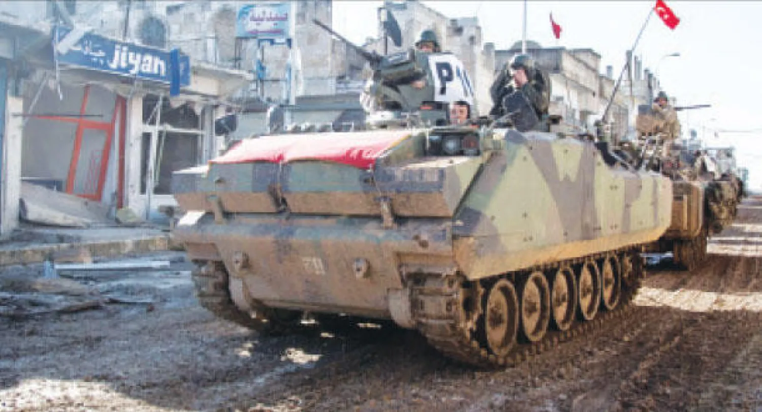 دبابة تركية في أحد شوارع مدينة كوباني السورية بعد الانتهاء من مهمة نقل ضريح سلمان شاه أمس (إ.ب.أ)
