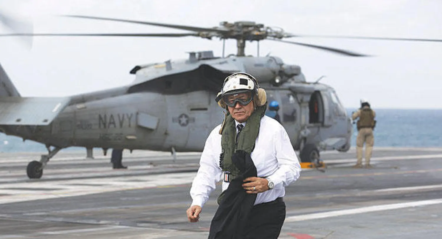جان إيف لودريان وزير الدفاع الفرنسي يخرج من طائرة هليكوبتر على متن حاملة الطائرات ذات الدفع النووي «شارل ديغول» في مياه الخليج أمس (أ.ف.ب)
