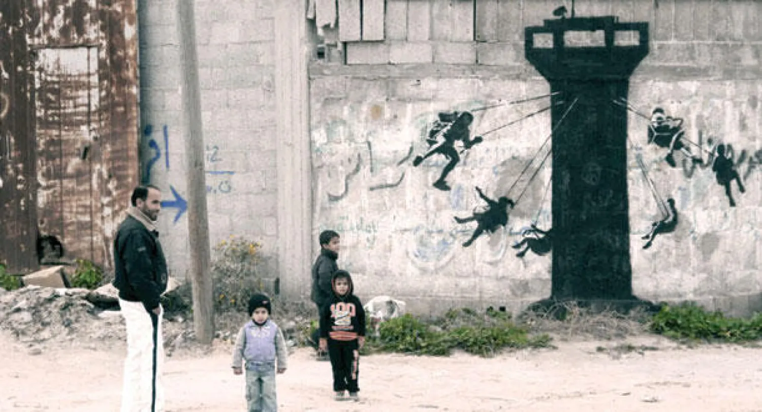 رسم بانكسي على أحد الحوائط في غزه معبرا عن الأزمه التي يعيشها السكان