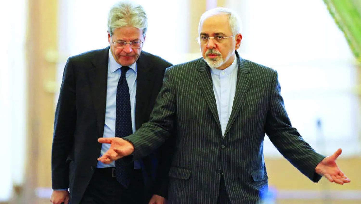 وزير الخارجية الإيراني محمد جواد ظريف لدى استقباله نظيره الإيطالي باولو جنتيلوني في طهران أمس (أ.ب)