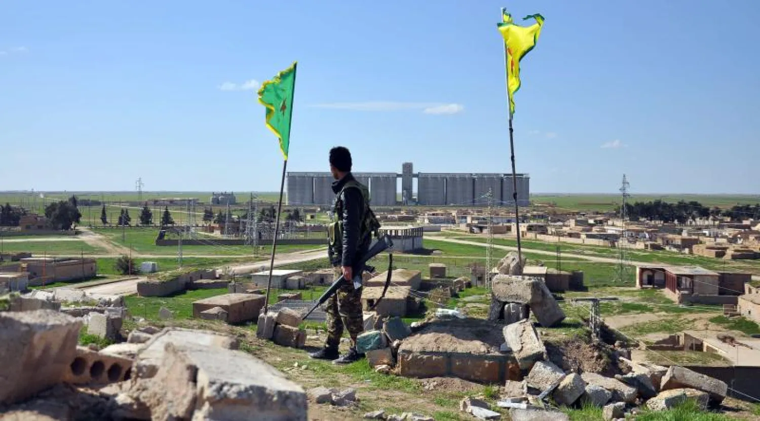 مقاتل من قوات حماية الشعب الكردية يقف على تلة تطل على قرية تل حميس شمال شرق سوريا (أ.ف.ب)