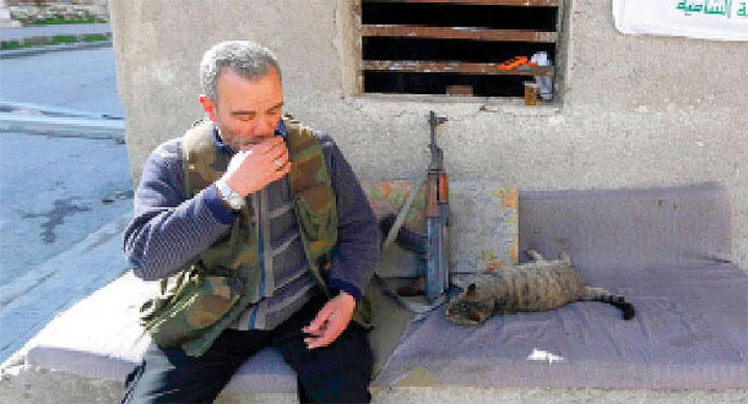 مقاتل من «الجبهة الشامية» في لحظة استراحة بحي الزبدية بمدينة حلب أمس (رويترز)