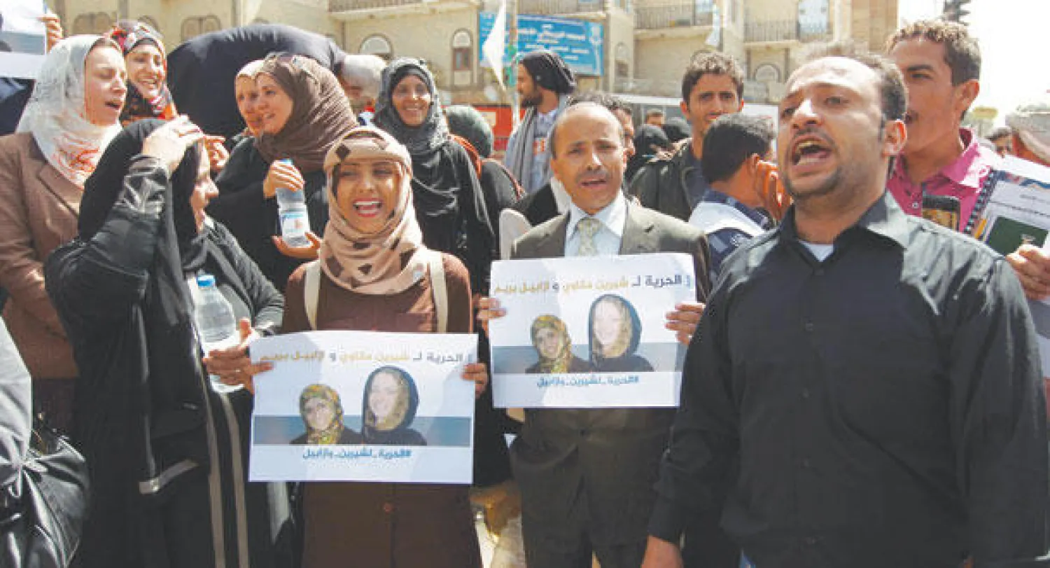 يمنيون في احتجاجات مطالبة بإطلاق سراح الرهينتين الفرنسية إيزابيل برايم ومترجمتها شيرين مكاوي في صنعاء أمس (أ.ف.ب)
