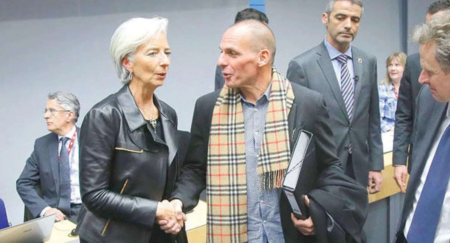 المدير العام لصندوق النقد الدولي كريستين لاغارد تصافح وزير المالية اليوناني يانيس فاروفاكيس على هامش اجتماع وزراء مالية مجموعة اليورو الخاص في مقر مجلس الاتحاد الأوروبي في بروكسل أمس (إ.ب.أ)