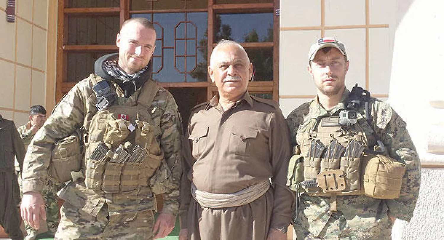 القيادي في قوات البيشمركة الكردية شيخ جعفر مصطفى يتوسط الجندي الأميركي السابق باتريك ماكسويل ورفيقه الكندي ديلون هيلير (نيويورك تايمز)