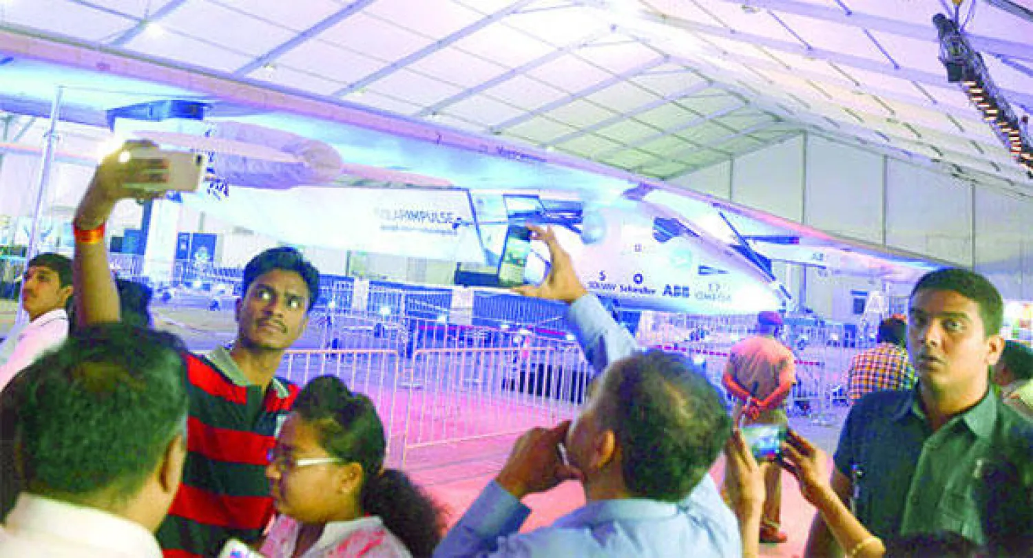 زوار هنود يلتقطون صورا للطائرة الشمسية الوحيدة في العالم خلال توقفها في مطار سردار فالابهائي الدولي في أحمد آباد في الهند (أ.ب)