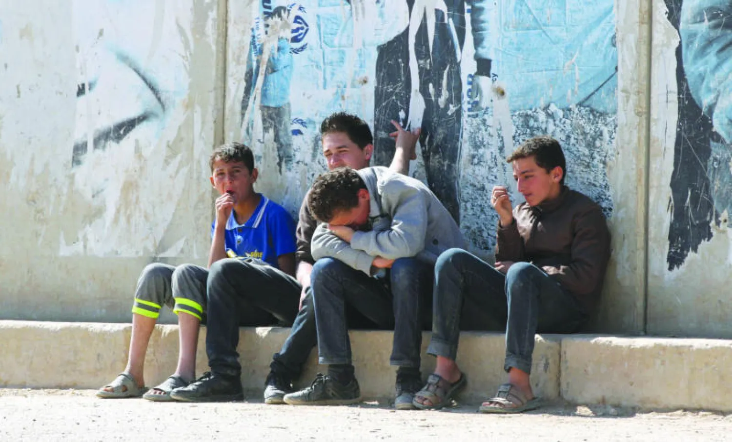 لاجئون سوريون على مدخل مخيم الزعتري شمال الأردن هربوا من القصف العنيف على مناطقهم من قبل قوات النظام (إ.ب.أ)