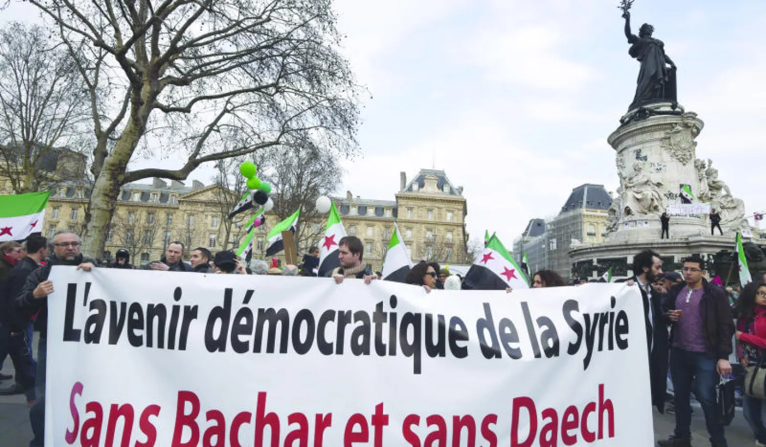 متظاهرون بمناسبة 4 سنوات على الثورة السورية في باريس أمس ولافتة: «مستقبل سوريا الديمقراطي دون بشار و(داعش)» (أ.ف.ب)