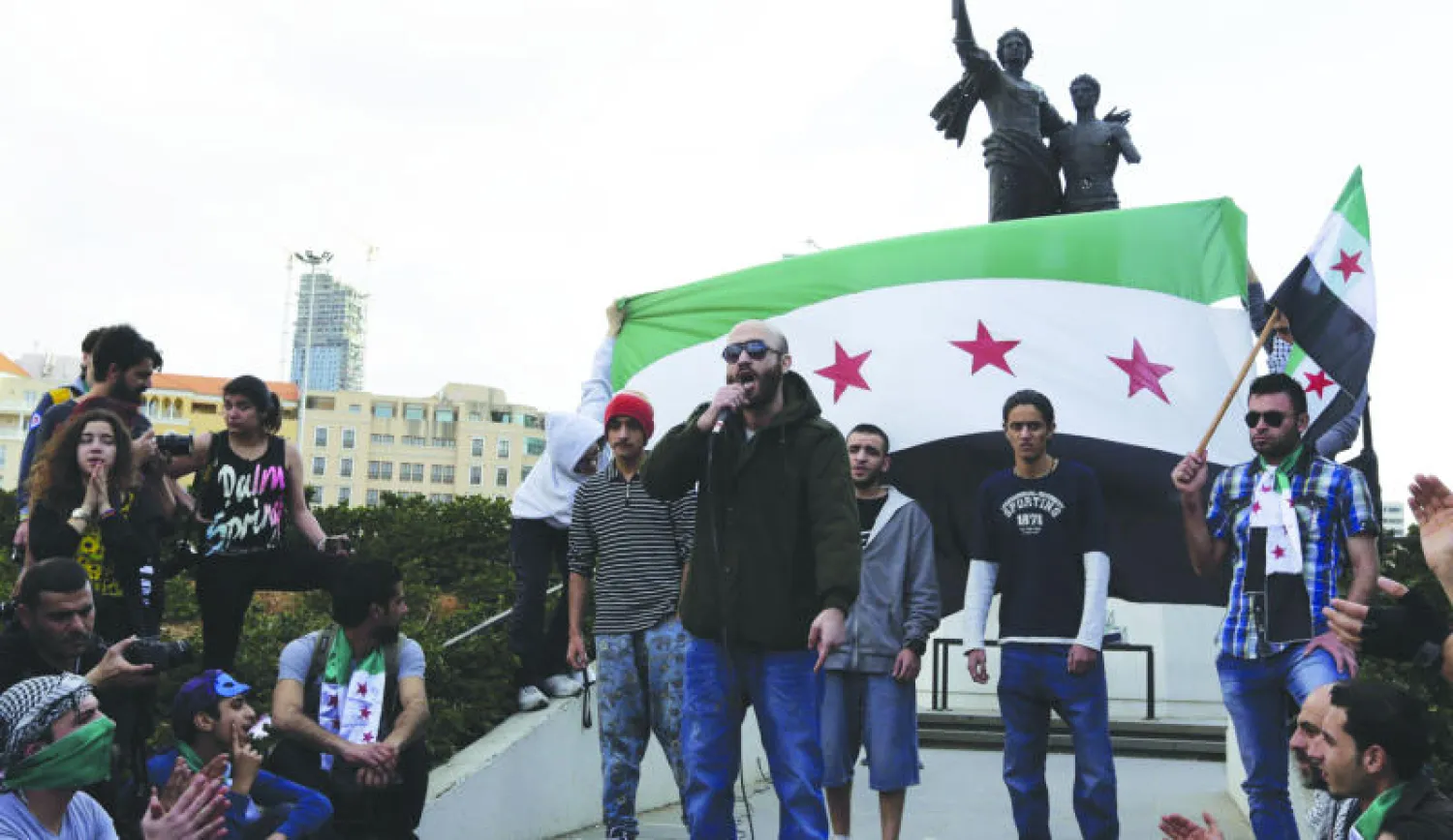 لبنانيون وسوريون يحتفلون أمس بذكرى الثورة السورية في ساحة لشهداء بالعاصمة اللبنانية (أ.ف.ب)