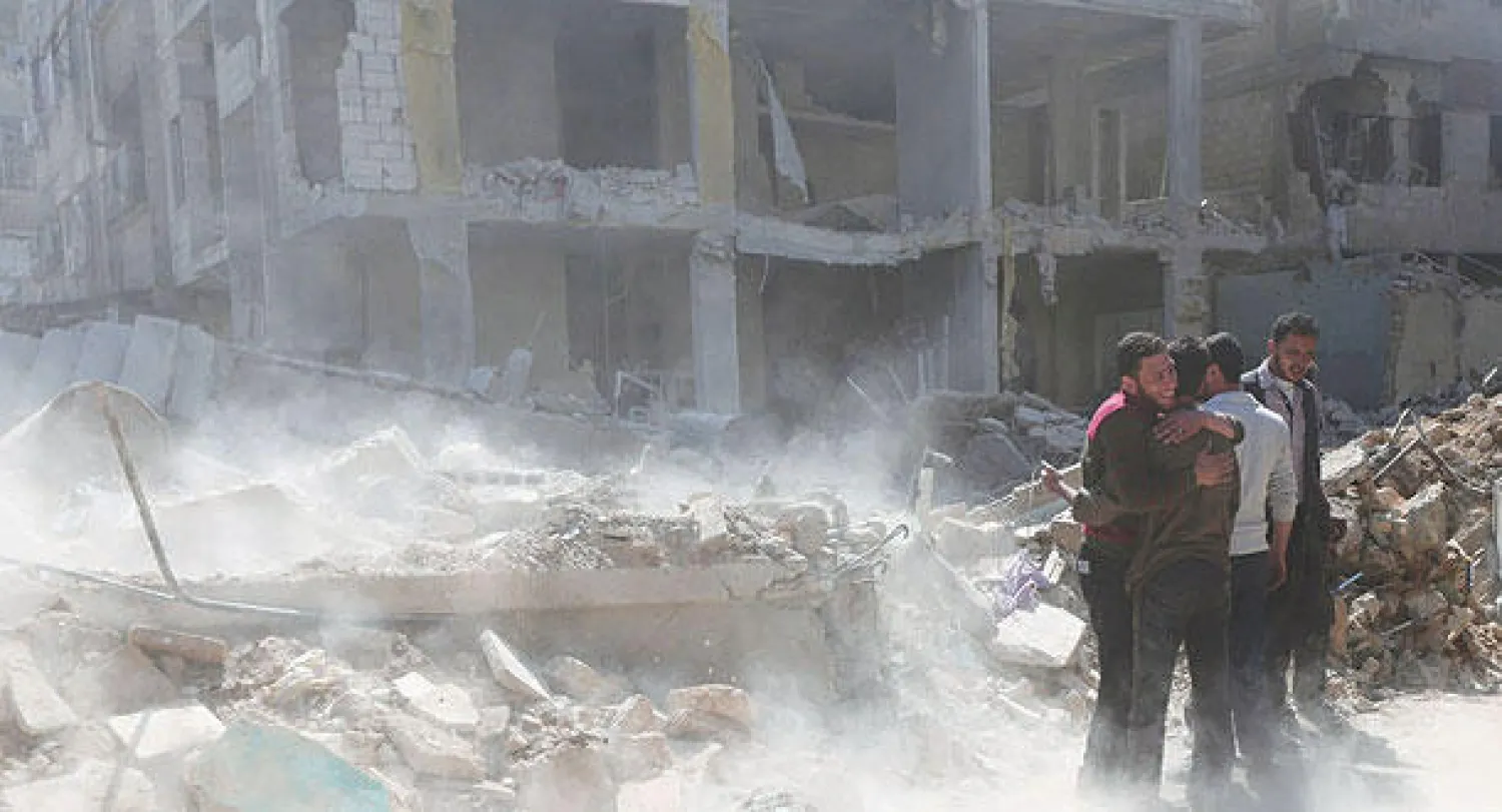 سكان بلدة دوما بالغوطة الشرقية لدمشق يواسون بعضهم البعض وسط الدمار الذي خلفه قصف طائرات النظام أول من أمس (رويترز)