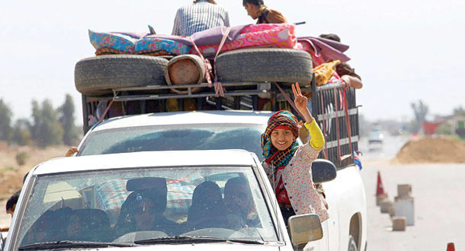 نازحون من ناحية العلم المحررة من سيطرة تنظيم داعش يعودون إليها أمس (رويترز)