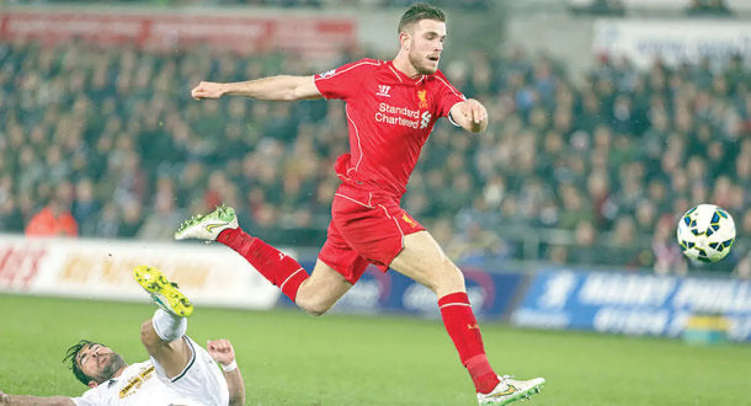 هندرسون لاعب ليفربول يتابع الكرة التي اصطدمت بقدمه من مدافع سوانزي وهي في طريقها للشباك (إ.ب.أ)