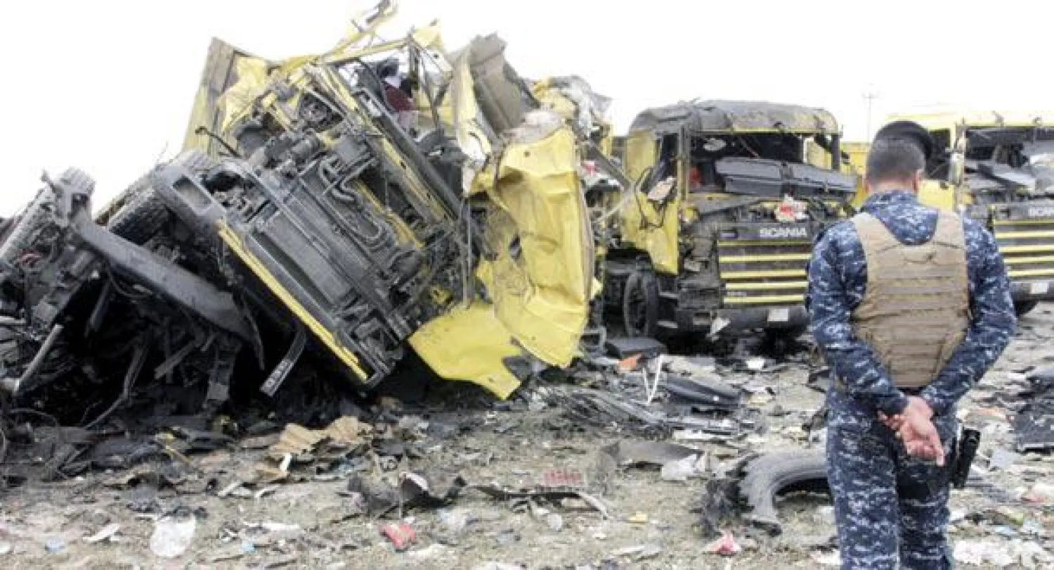 عنصر أمن عراقي يعاين آثار تفجير قرب ميناء أم قصر أمس (إ.ب.أ)