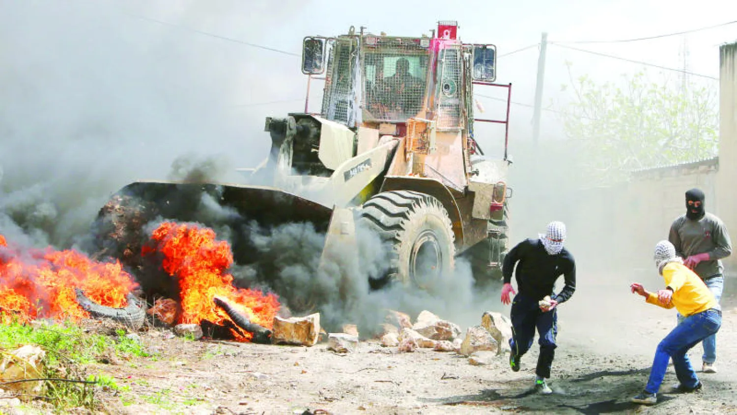 فلسطينيون يرمون قوات إسرائيلية بالحجارة خلال مظاهرة نظمت في بلدة كفر قدوم بالقرب من نابلس أمس (أ.ف.ب)
