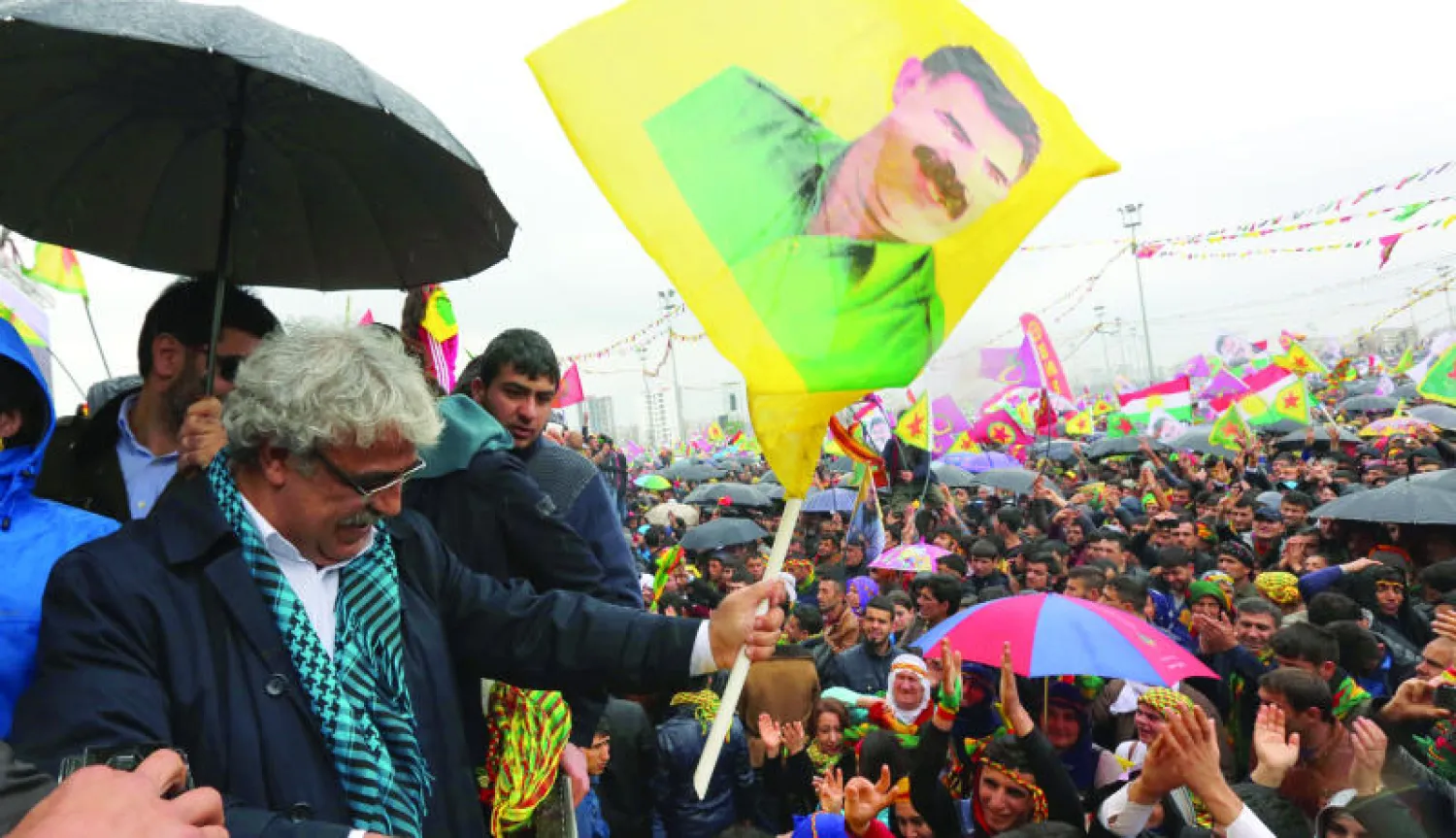أحد مرشحي الحزب الكردستاني لانتخابات البرلمان التركي يرفع صورة لعبد الله أوجلان بمناسبة الاحتفال بعيد نوروز في ديار بكر أمس (أ.ب)