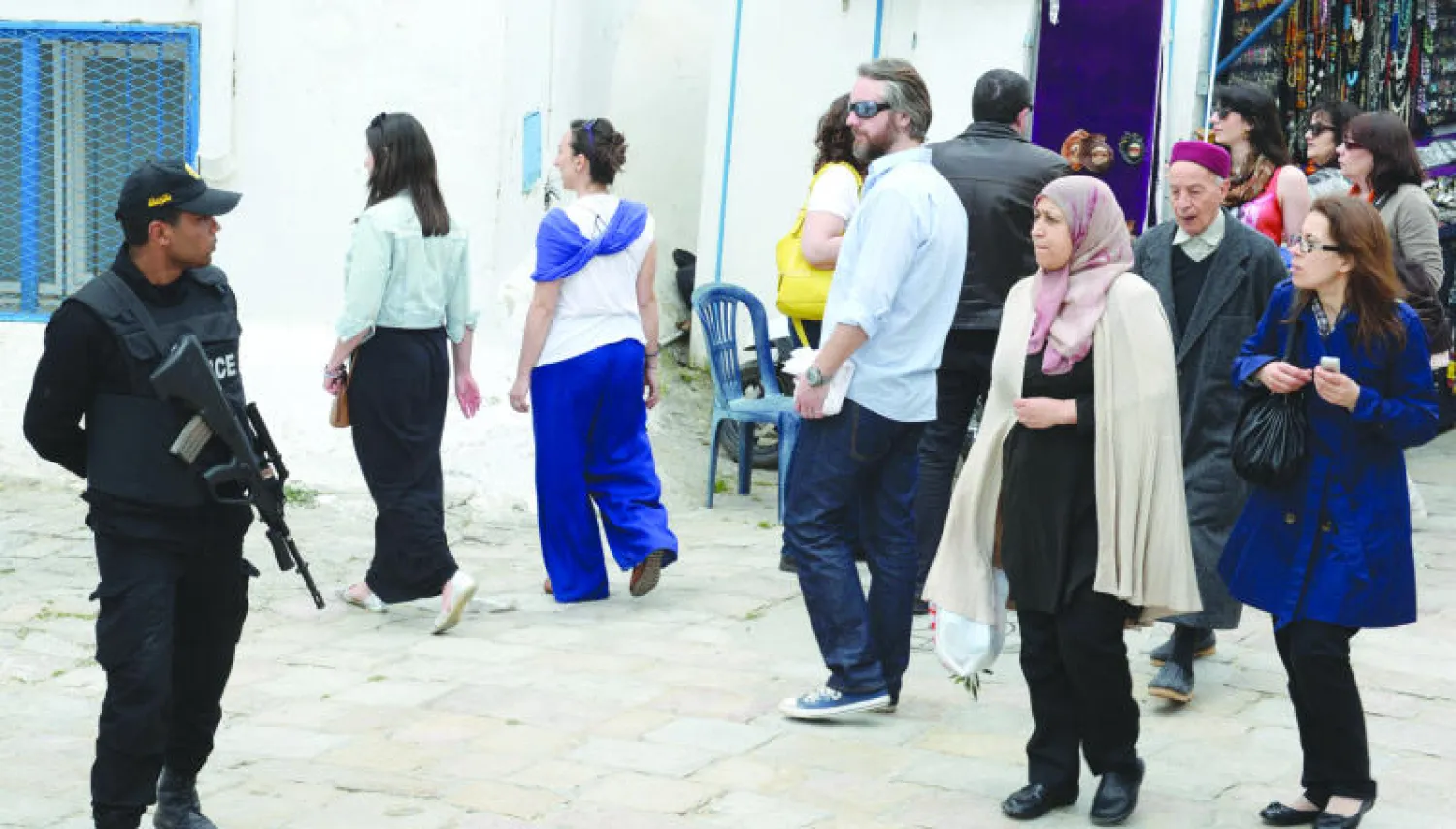 جندي تونسي في أحد شوارع مدينة بوسعيد التونسية بينما السياح والمواطنون يمرون من حوله في أمن وهدوء (أ. ف. ب)