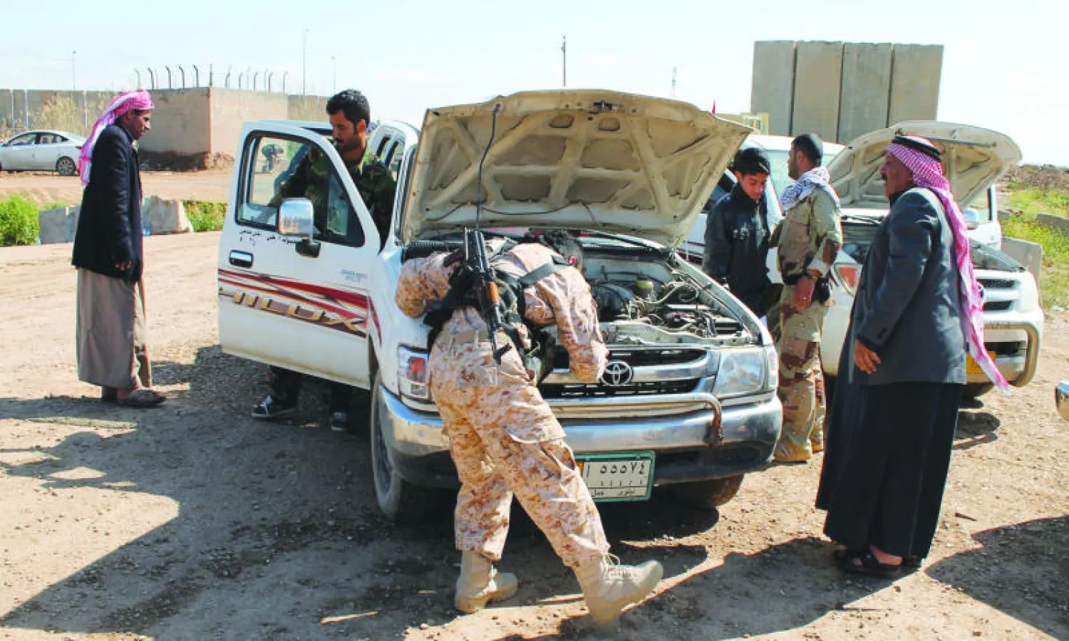 عنصر من البيشمركة يفتش سيارة يستقلها نازحون عائدون إلى مناطقهم قرب كركوك أمس (إ.ب.أ)