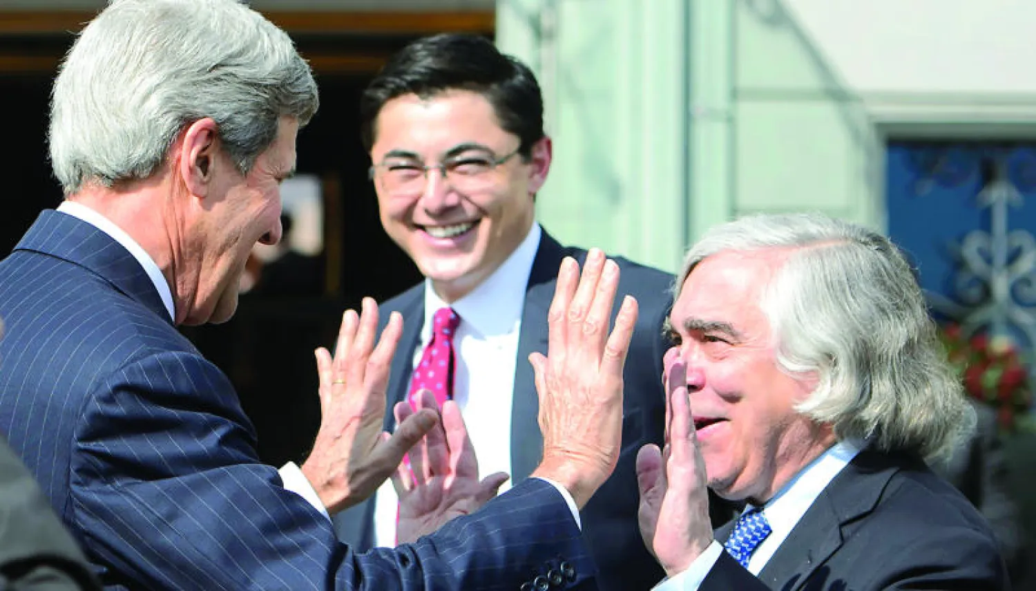 وزير الخارجية الأميركي جون كيري يمزح مع وزير الطاقة الأميركي إرنست مونيز خارج الفندق الذي  يستضيف المباحثات النووية مع إيران في لوزان أمس (أ.ب)