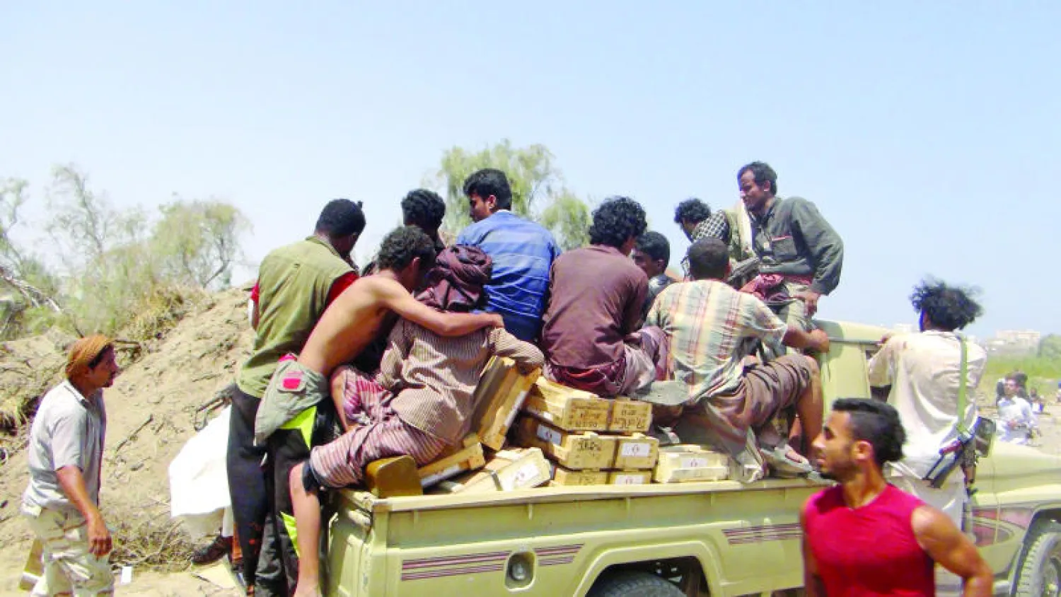 يمنيون في سيارة نقل بعد أن هربوا صناديق أسلحة من مخازن سلاح في عدن أمس (رويترز)