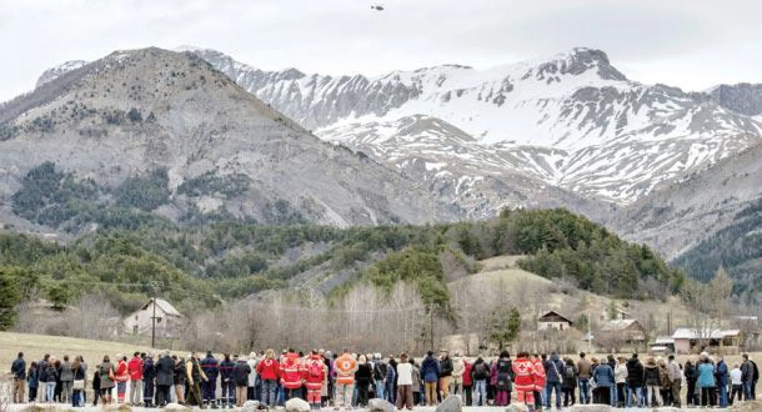 سكان وأعضاء بمنظمة الصليب الأحمر حضروا أمس قداسا لتذكر ضحايا الطائرة في بلدة «لو فيرني» بالقرب من موقع تحطم الرحلة في الألب (أ.ف.ب)