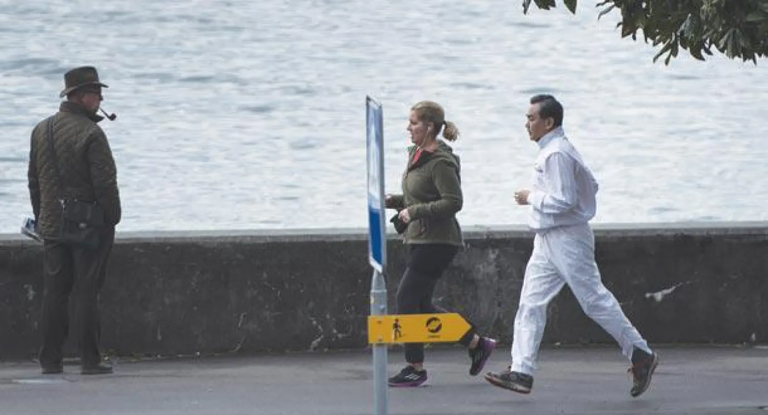 وزير خارجية الصين وانغ يي يركض قرب بحيرة ليمان في مدينة لوزان امس(أ.ب)