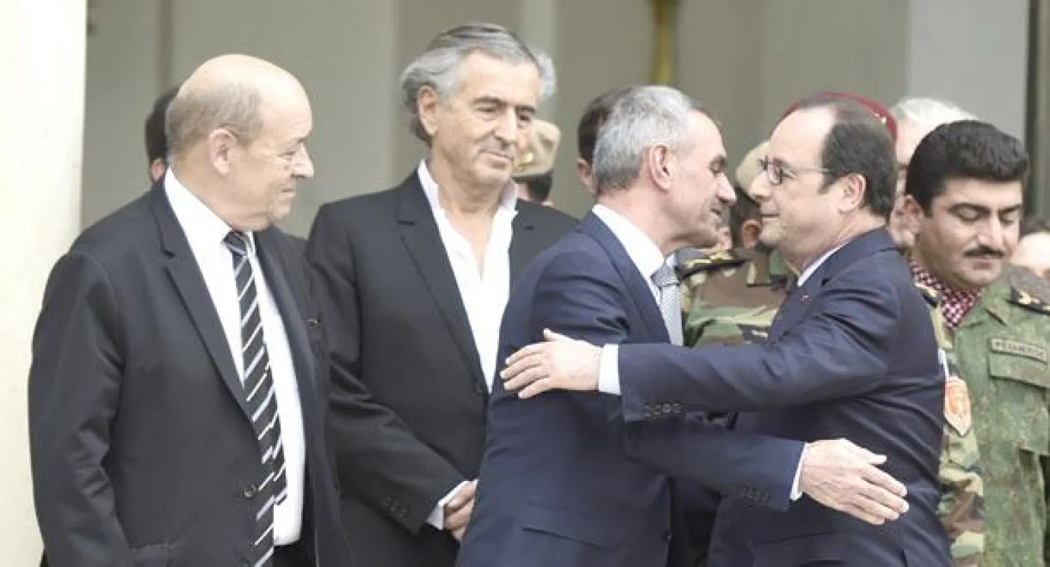 الرئيس الفرنسي فرنسوا هولاند مودعا وزير البيشمركة الكردي مصطفى سيد قادر بعد مباحثاتهما في الإليزيه أمس وبدا الكاتب برنار ليفي (أ.ف.ب)