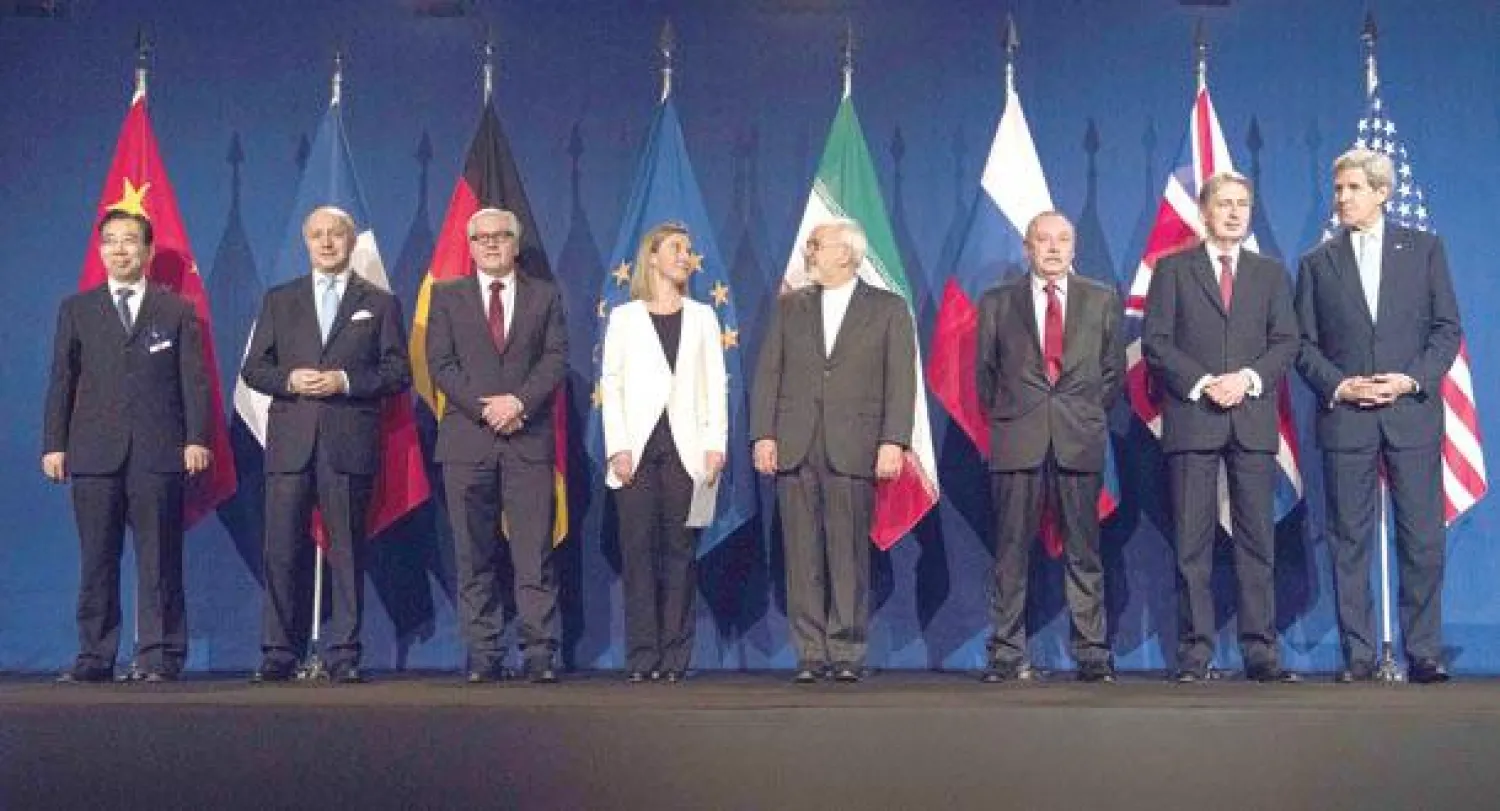 المسؤولون في المفاوضات النووية في صورة جماعية بعد التوصل إلى اتفاق أمس من اليسار: مساعد وزير الخارجية الصيني ووزراء خارجية فرنسا وألمانيا والاتحاد الأوروبي وإيران ونائب المدير السياسي لوزارة الخارجية الروسية ووزيرا خارجية المملكة المتحدة والولايات المتحدة (أ.ف.ب)