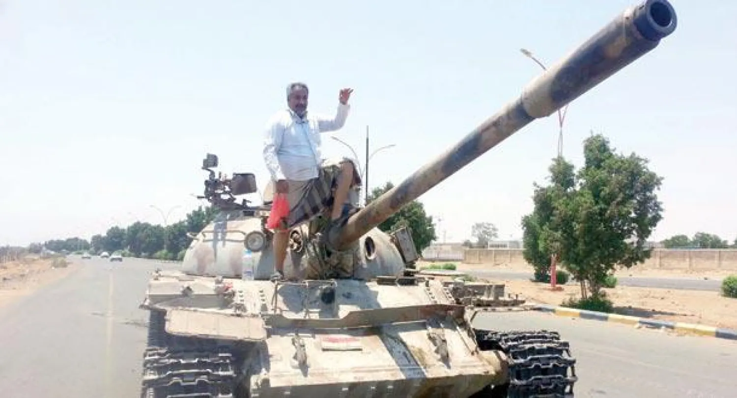 عضو حزب الحراك الجنوبي د. محمد حلبوب يقف على دبابة عسكرية، بعد نجاح اللجان الشعبية في الاستيلاء عليها مع أسلحة أخرى بمساندة الغطاء الجوي لقوات التحالف الدولي. («الشرق الأوسط»)