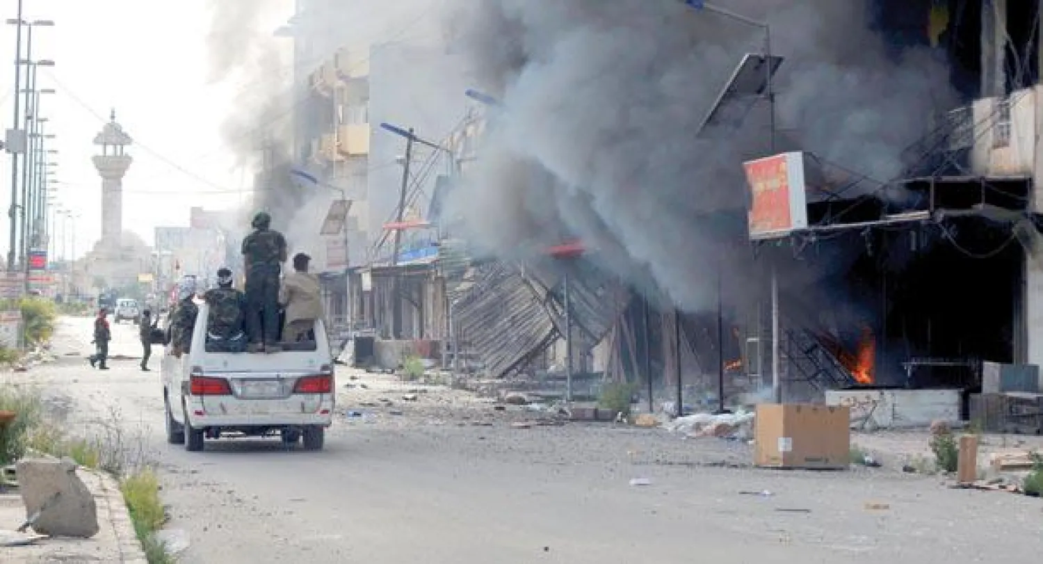 عناصر في الحشد الشعبي يستقلون سيارة في شارع تجاري بحي القادسية في تكريت أول من أمس (رويترز)