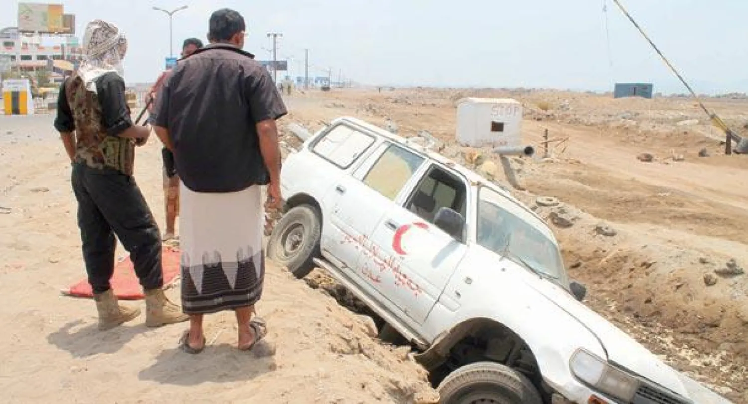 مسلحون من {الحراك الجنوبي} بجانب سيارة اسعاف أصيبت جراء هجمات الحوثيين في عدن أمس (أ.ف.ب)