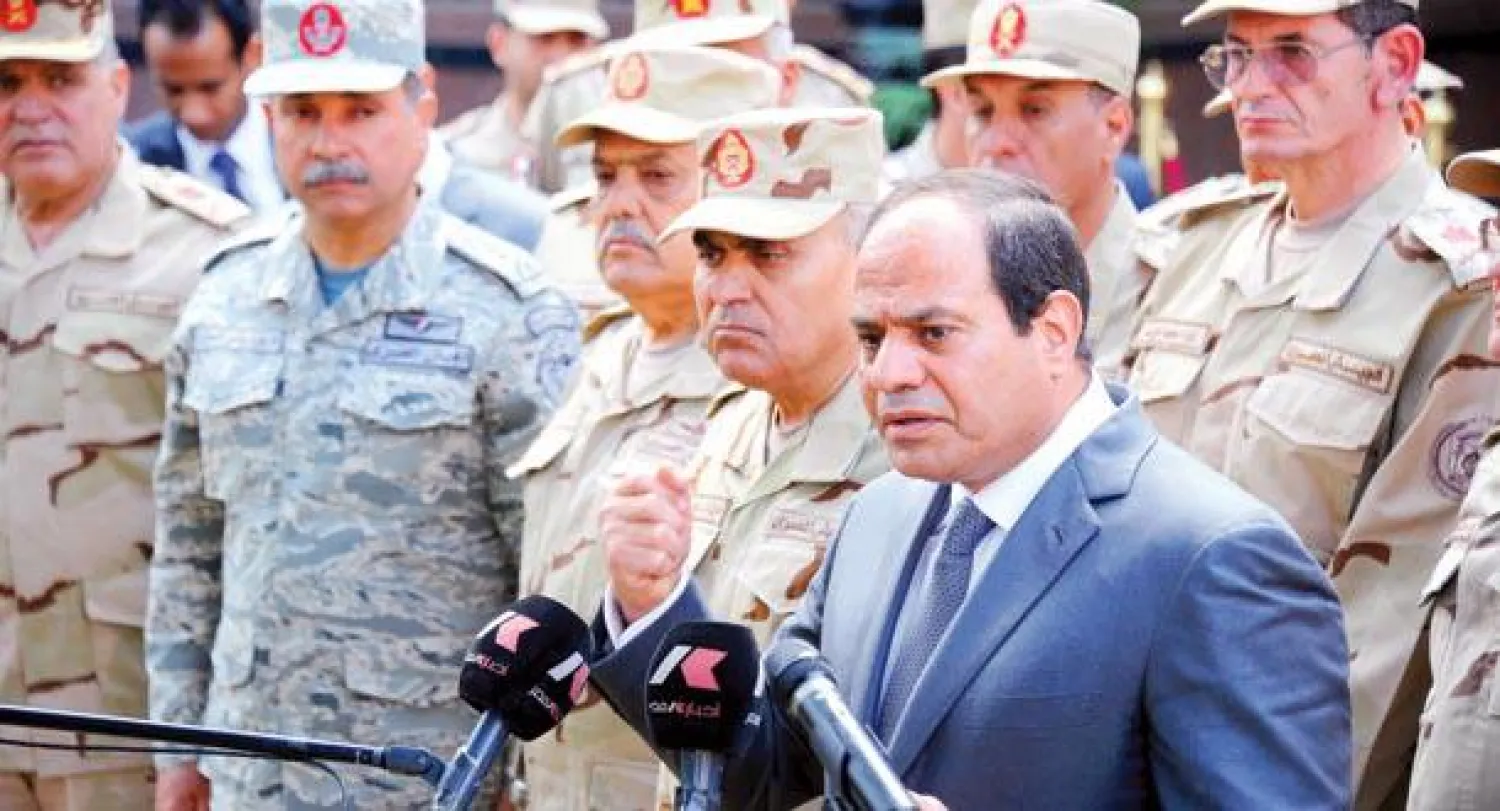 الرئيس السيسي محاطا بقادة المجلس الأعلى للقوات المسلحة عقب اجتماع المجلس في القاهرة أمس ({الشرق الأوسط})
