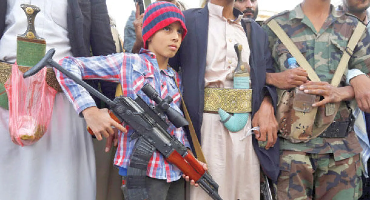 طفل يحمل السلاح خلال تجمع للحوثيين في صنعاء أمس (إ.ب.أ)