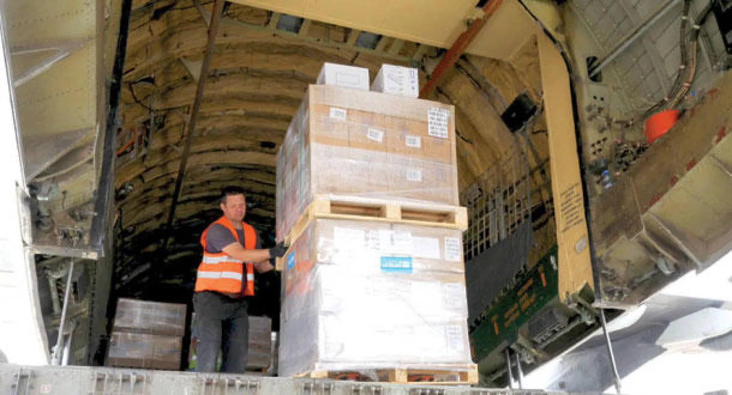 عمال إغاثة ينزلون مساعدات إنسانية من طائرة في مطار صنعاء أمس (رويترز)