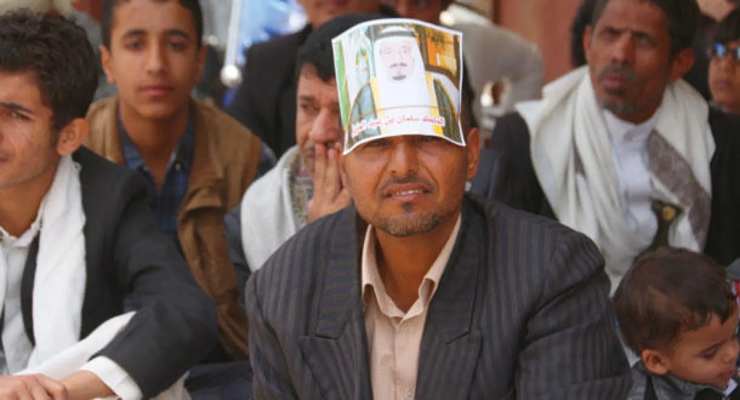 يمني يضع صورة الملك سلمان بن عبد العزيز على جبهته أثناء استماعه لخطبة الجمعة في أحد مساجد مدينة إب أمس (غيتي)