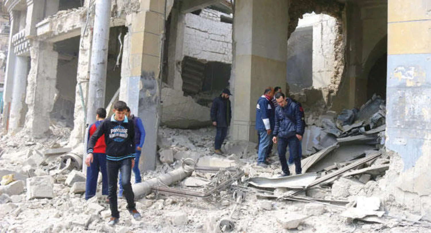 سوريون يعانيون حجم الدمار الذي خلفه قصف طيران النظام على منطقة جب القبة في ريف حلب أمس (رويترز)