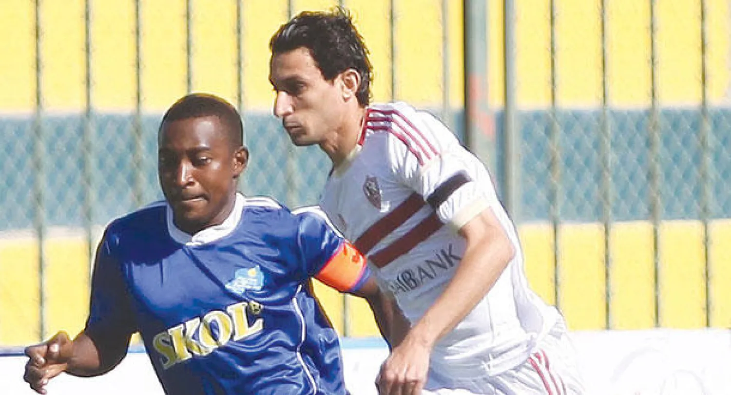 أيمن حفني لاعب الزمالك (يمين) يحاول تخطي مدافع رايون سبورت الرواندي في كأس الاتحاد الأفريقي (أ.ف.ب)