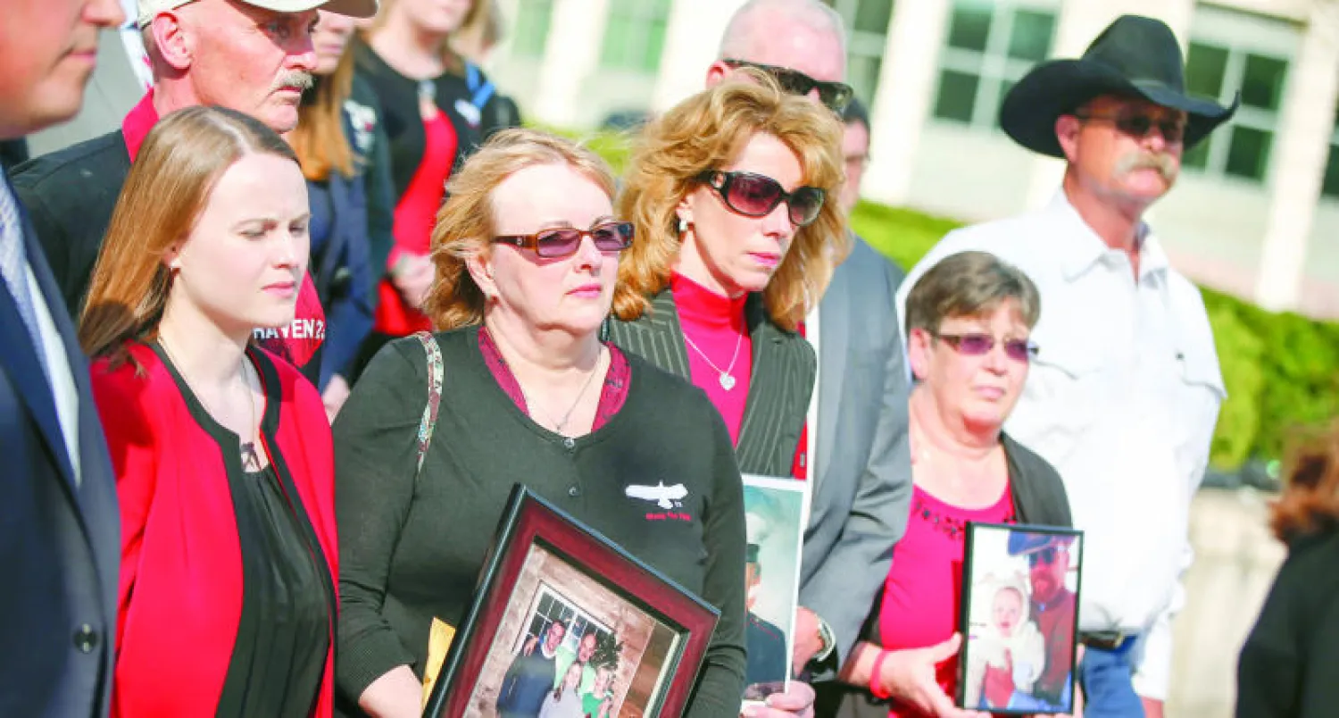 عوائل الحراس السابقين في (بلاك ووتر) الذين قتلوا 14 عراقيا عام 2007 والذين حكم عليهم القضاء بالسجن المؤبد و30 عاما، يقفون خارج المحكمة في واشنطن اول من امس(أ.ب)