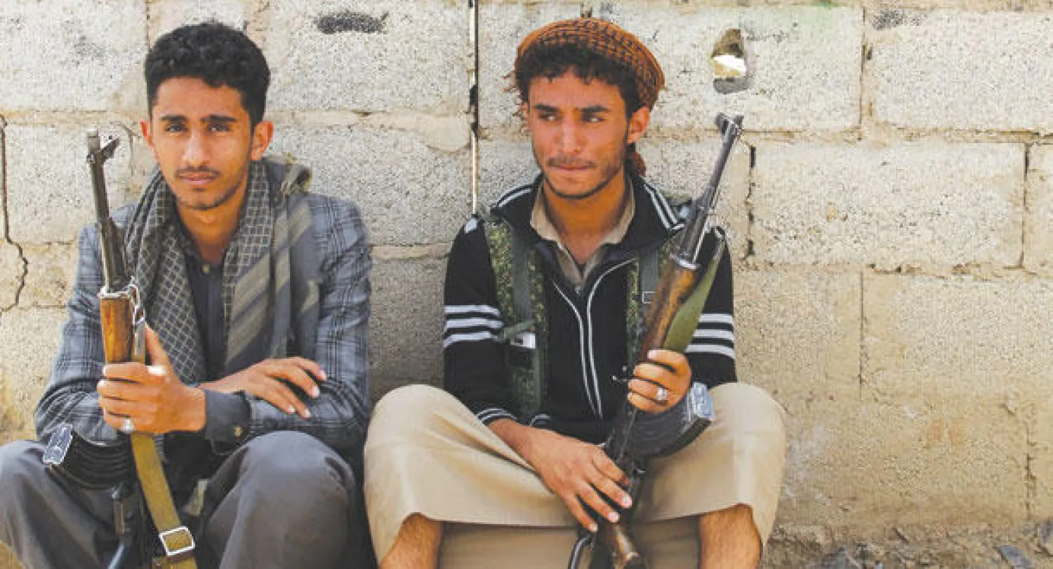 مسلحان حوثيان يجلسان على الأرض في صنعاء أمس (إ.ب.أ)