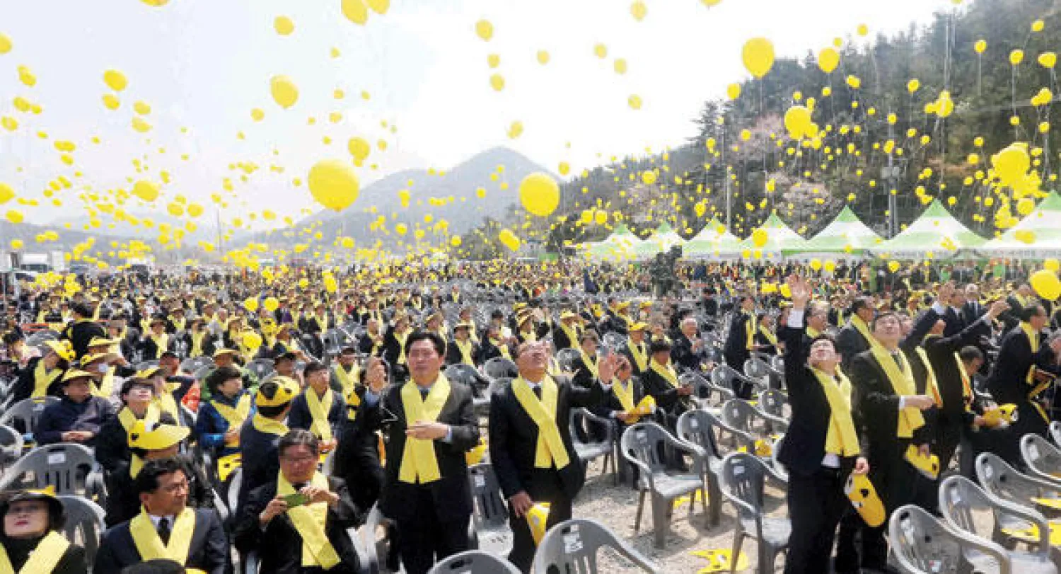 كوريون جنوبيون يطلقون بالونات في الهواء بجزيرة جيندو بمناسبة الذكرى السنوية الأولى لضحايا كارثة العبارة الغارقة أمس (أ.ب)