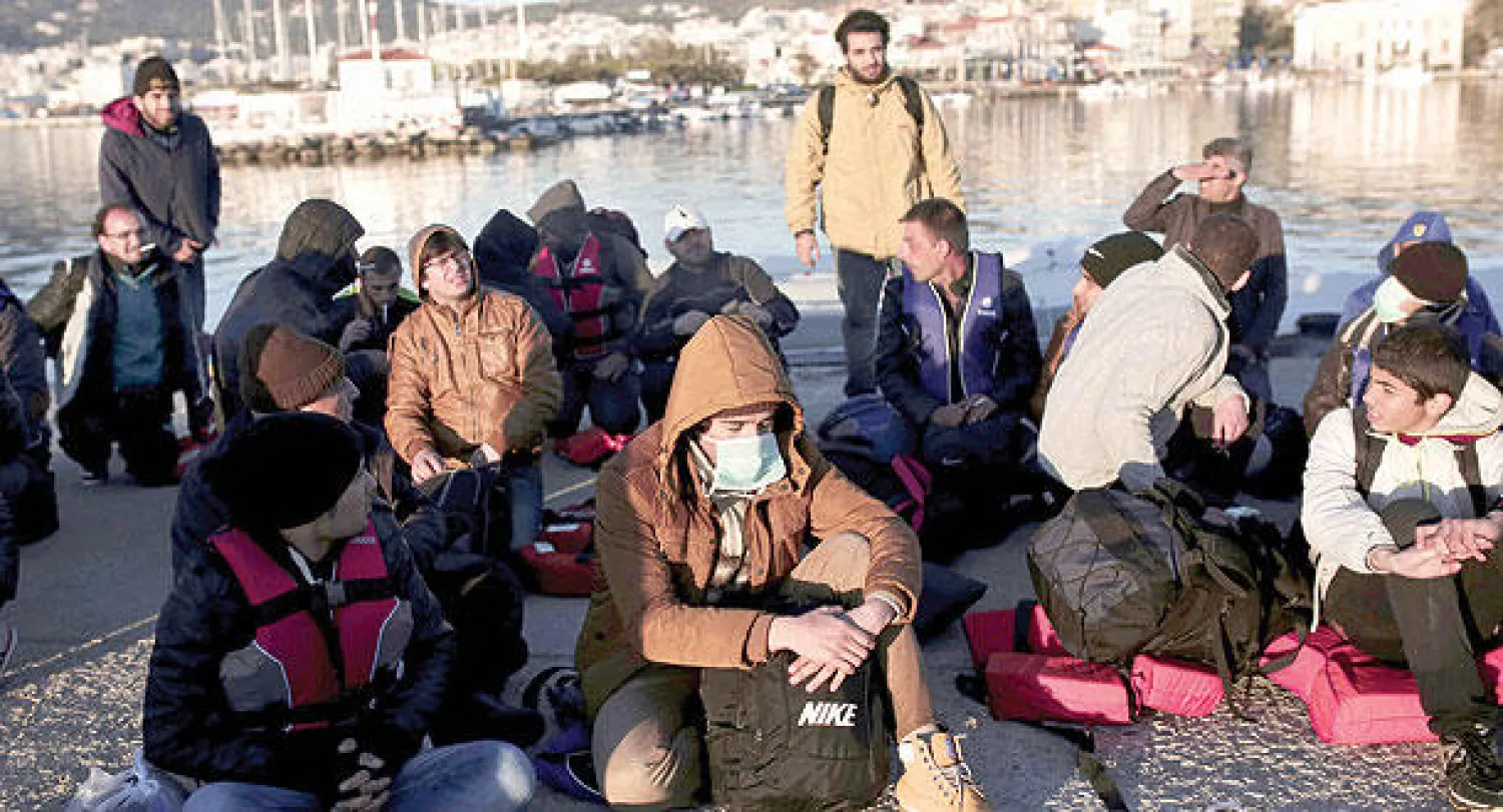 جون كيريسوريون لاجئون وصلوا إلى الشواطئ اليونانية أول من أمس في سفن التهريب التي تتم عبر بحر إيجه من تركيا (إ.ف.ب)