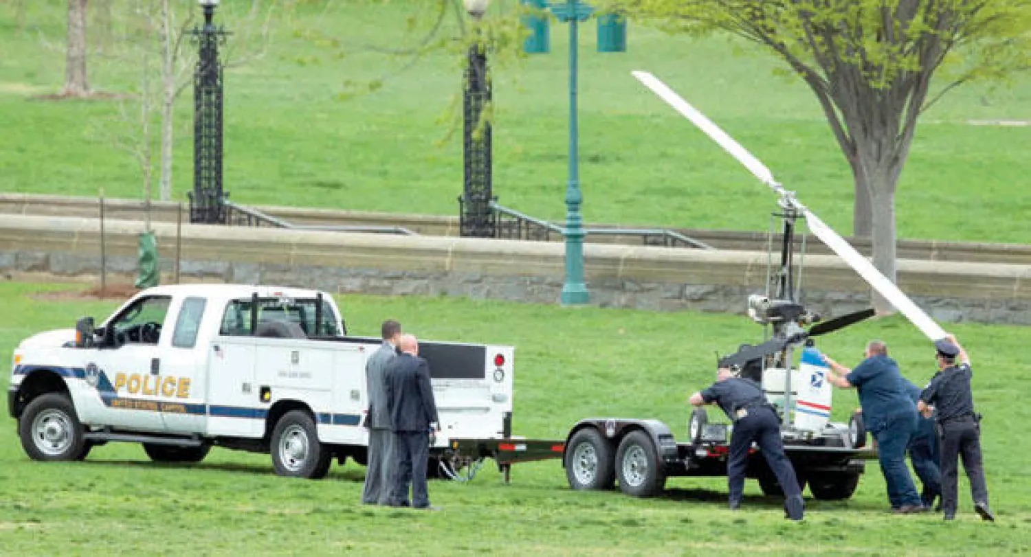 الشرطة تنقل طائرة الهليكوبتر الصغيرة بعدما حط بها صاحبها قرب مبنى الكابيتول منتهكا الحظر الجوي في المنطقة مساء أول من أمس (أ.ب)