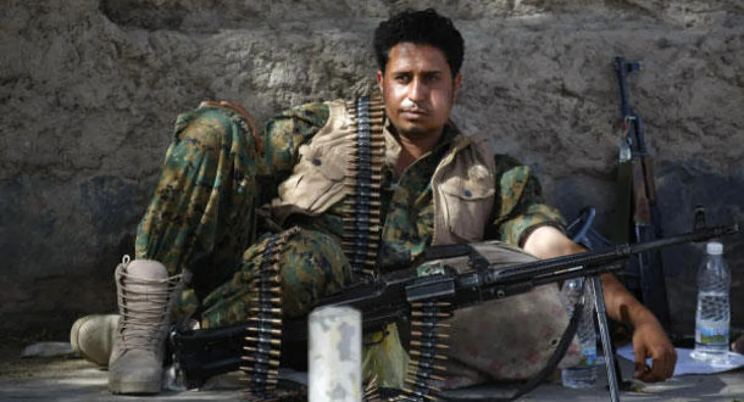 مسلح حوثي بزي الجيش اليمني قرب أحد المواقع في صنعاء يخزن القات أمس (إ.ب)