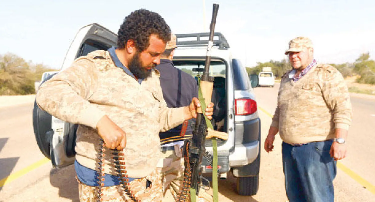 مقاتلون موالون لقوات فجر ليبيا يعدون أسلحتهم في مدينة سرت بعد ازدياد المواجهات بينهم وبين {داعش} (أ.ف.ب)