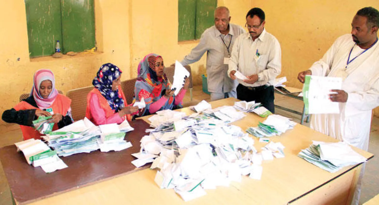 موظفون سودانيون في احد مراكز الاقتراع بالخرطوم يفرزون اوراق الانتخابات البرلمانية والرئاسية أمس (إ.ب.أ)