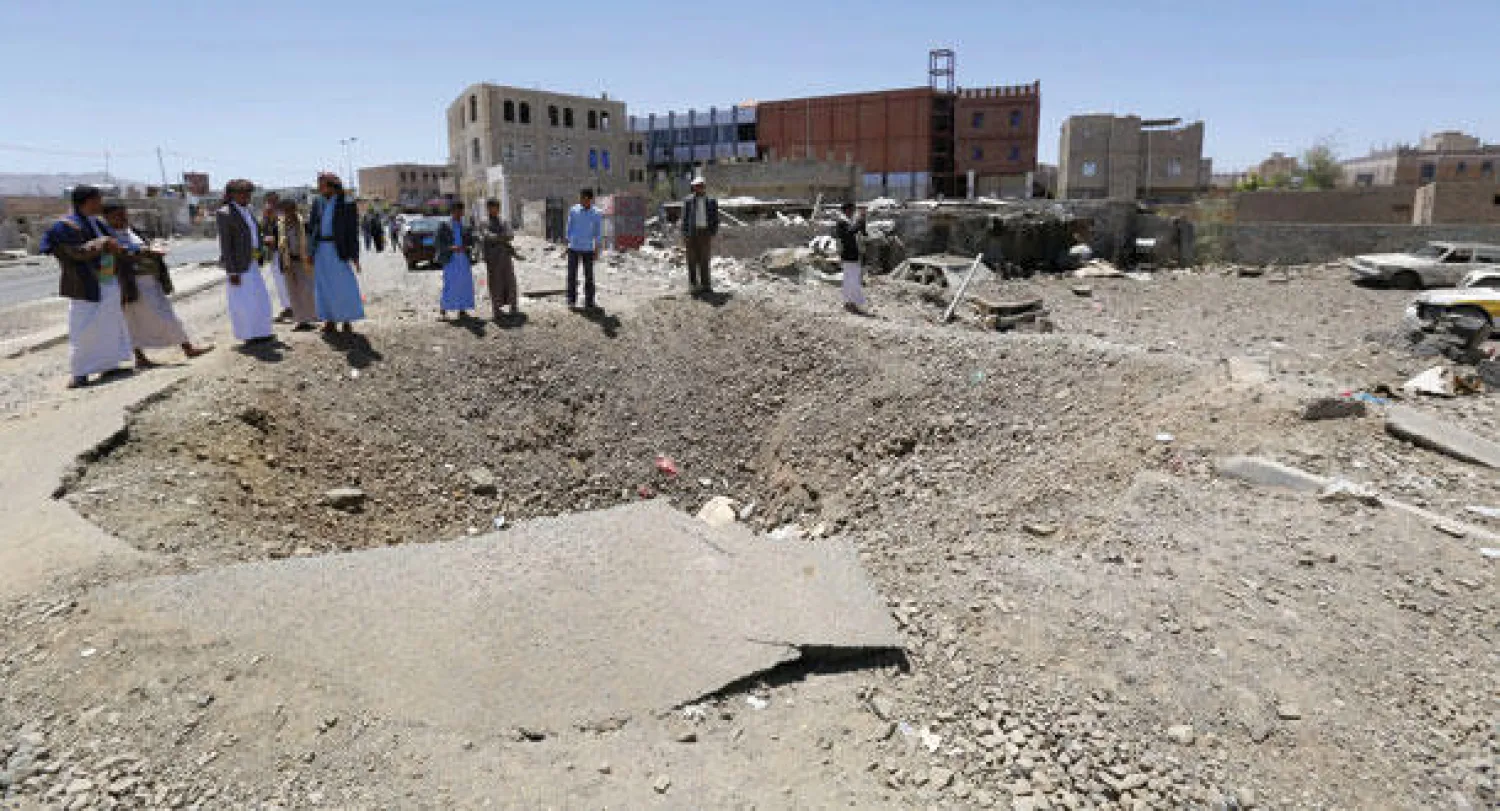يمنيون يقفون على مواقع استهدفتها قوات التحالف أثناء قصفها لمواقع الحوثيين في صنعاء أمس (إ.ب.أ)