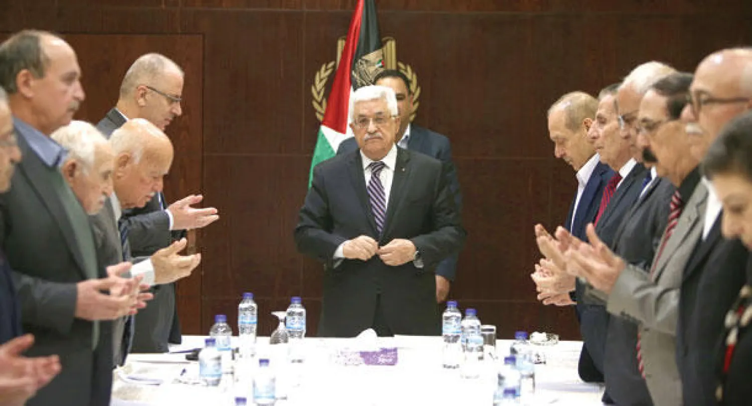 الرئيس عباس يتلو مع أعضاء الحكومة آيات من القرآن الكريم خلال اجتماع اللجنة التنفيذية لمنظمة التحرير في رام الله أمس (أ.ف.ب)